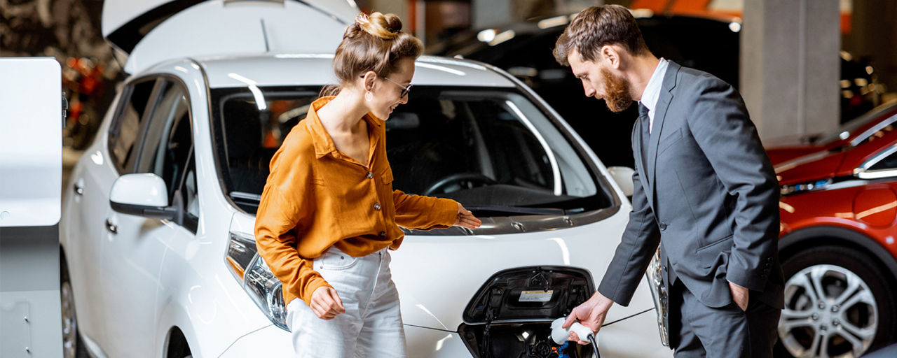 Mann und Frau stehen vor einem Auto