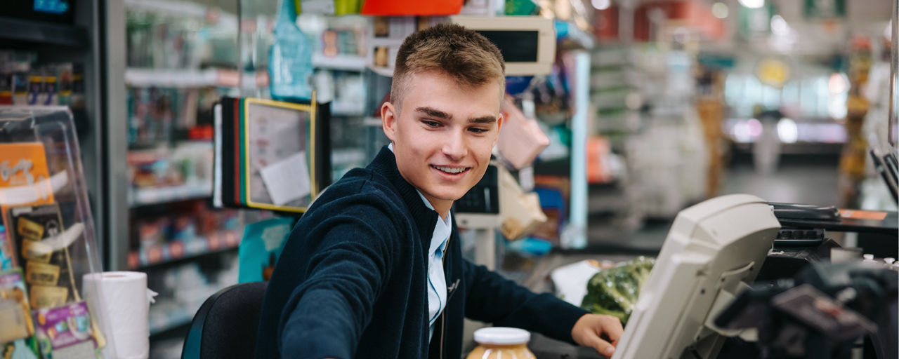 Junge Person an Supermarktkasse
