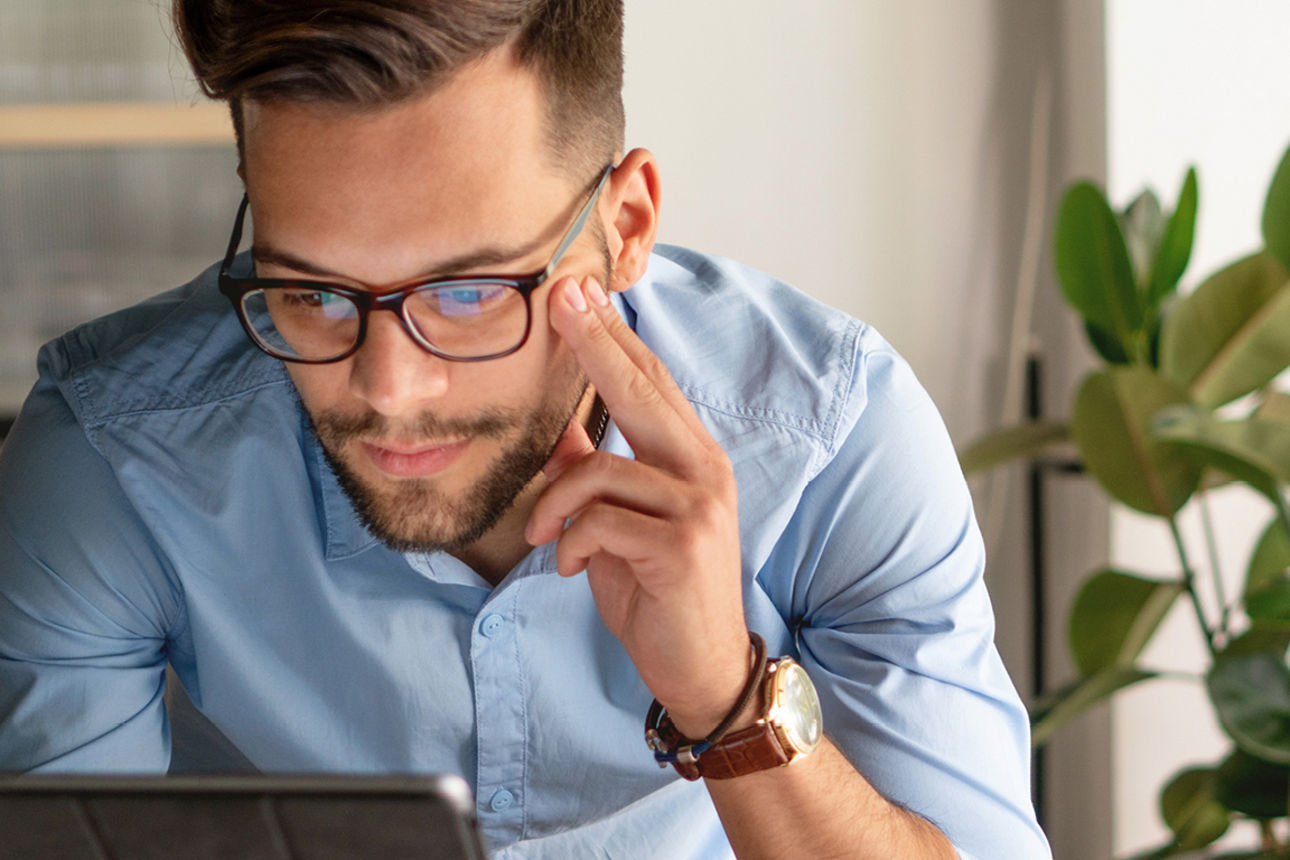 Mann mit Brille schaut auf ein Tablet