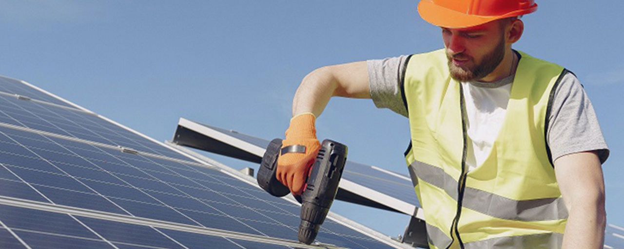 Mann auf dem Dach bringt Solarpanele an