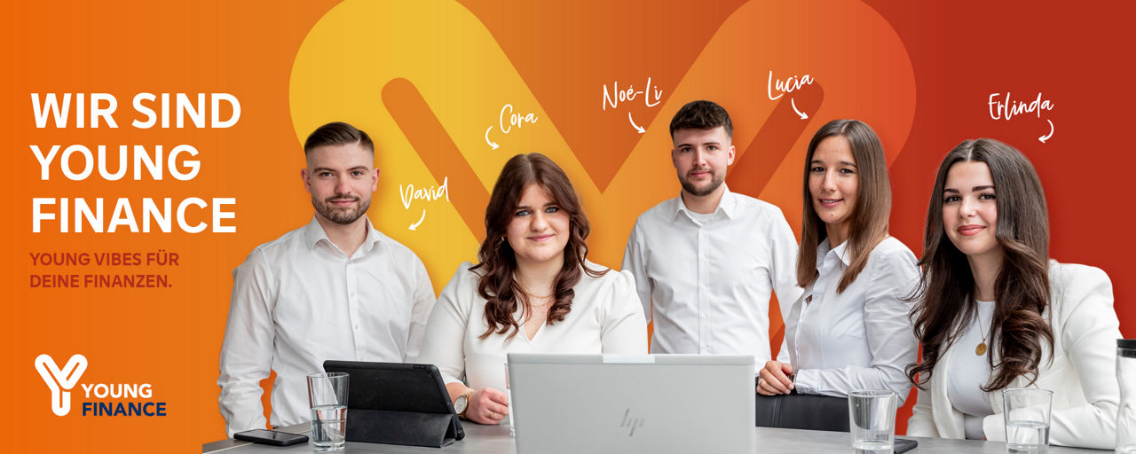 5 Personen stehen um einen Tisch mit Laptop, Tablet und Smartphone.