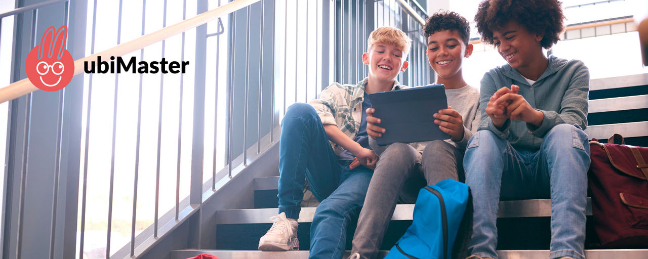 Drei Jungs sitzen auf einer Treppe und schauen in ein Tablet