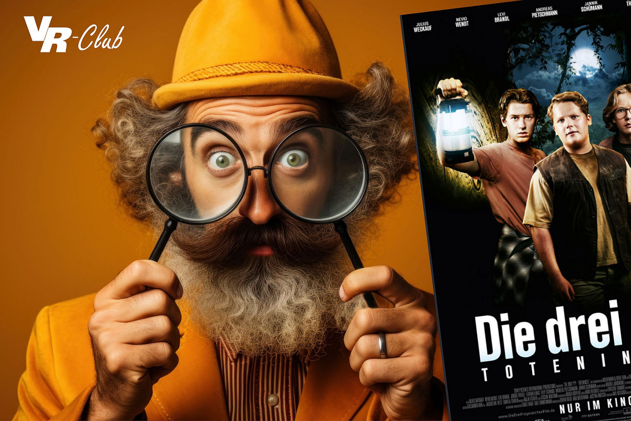 Mann mit Vollbart und gelbem Hut hält sich zwei Lupen vors Gesicht und schaut mit großen Augen hindurch, daneben ein Plakat