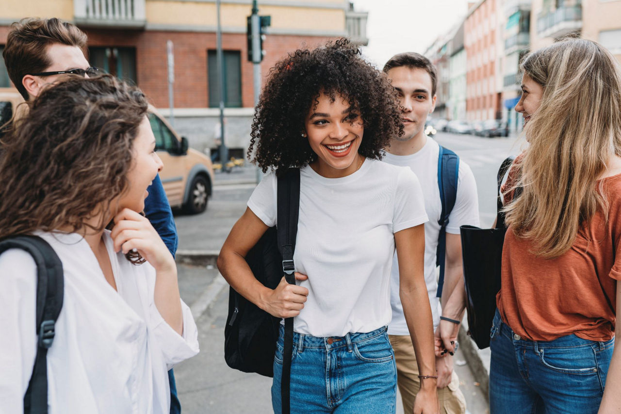 Freunde laufen nach der Schule zusammen nach Hause und lachen
