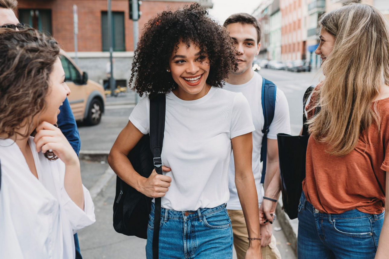 Freunde laufen nach der Schule zusammen nach Hause und lachen