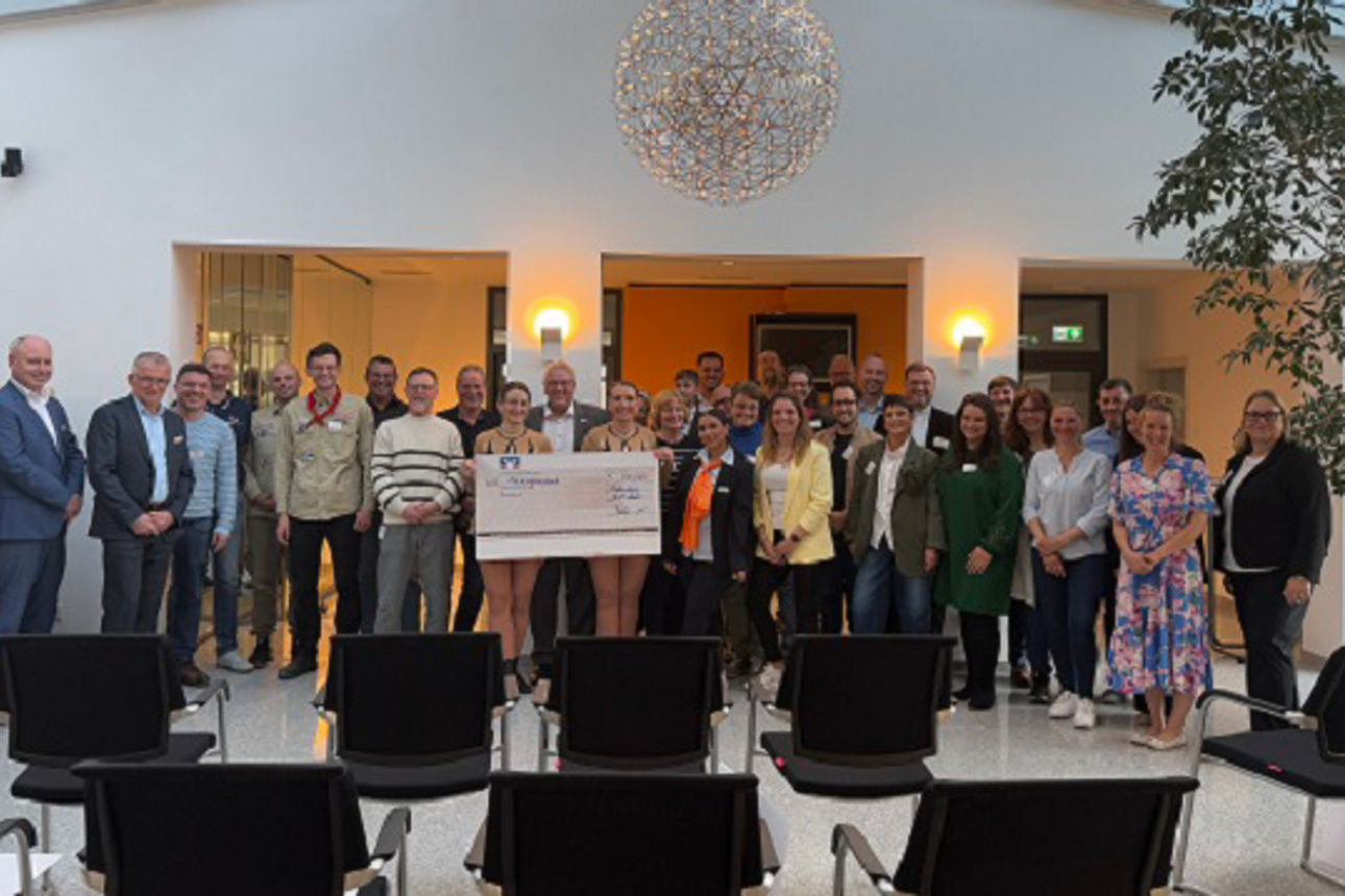 Foto von einer Gruppe von Menschen in einem großen Saal.