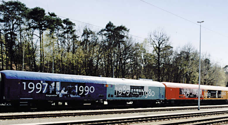 Historisches Bild Zug mit bunten Wagons und Jahreszahlen drauf