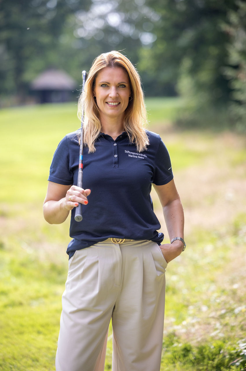 Martina Stehr, Bereichsleiterin Vorstandsstab der VBLH und Stiftungsvorständin auf dem Golfplatz mit Golfschläger