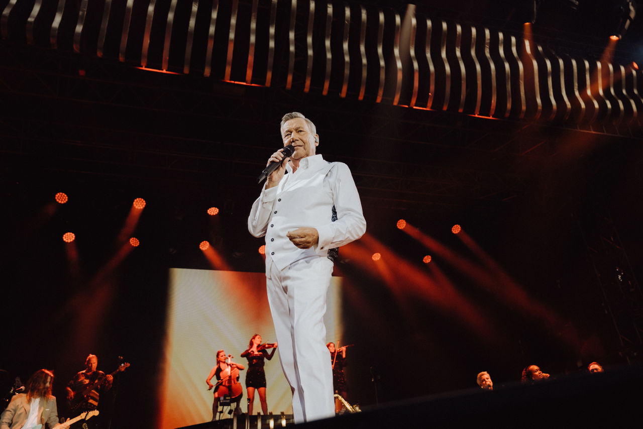 Schlagersänger Roland Kaiser auf der Bühne mit Mikrofon – Ankündigung seines Open-Air-Konzerts am 11. Juli 2025 im Sachs-Stad