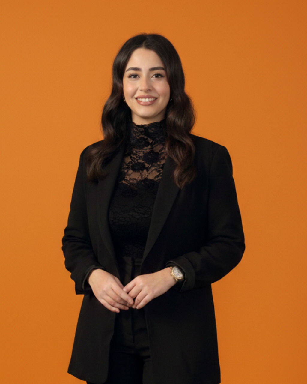 Lächelnde Frau in schwarzem Blazer vor orangefarbenem Hintergrund
