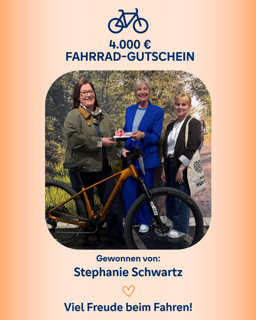 Aufnahme der Übergabe eines Fahrradgutscheins an die Gewinnerin