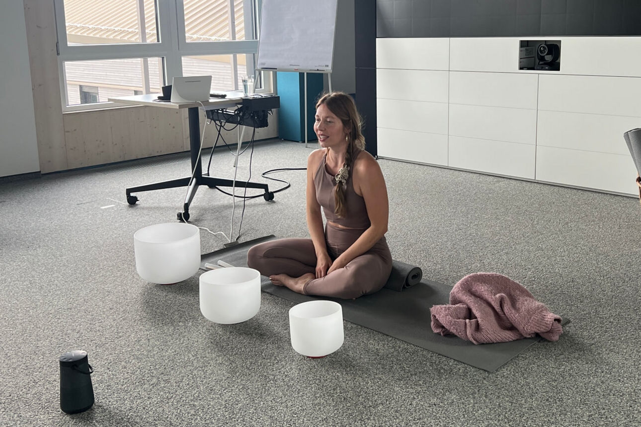 Yogalehrerin sitzt auf dem Boden und erklärt Übungen