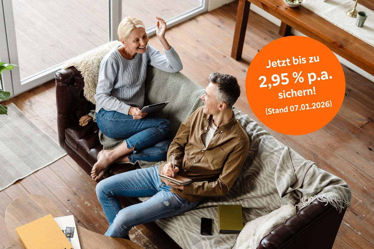 Ehepaar sitzt auf dem Sofa und spricht miteinander