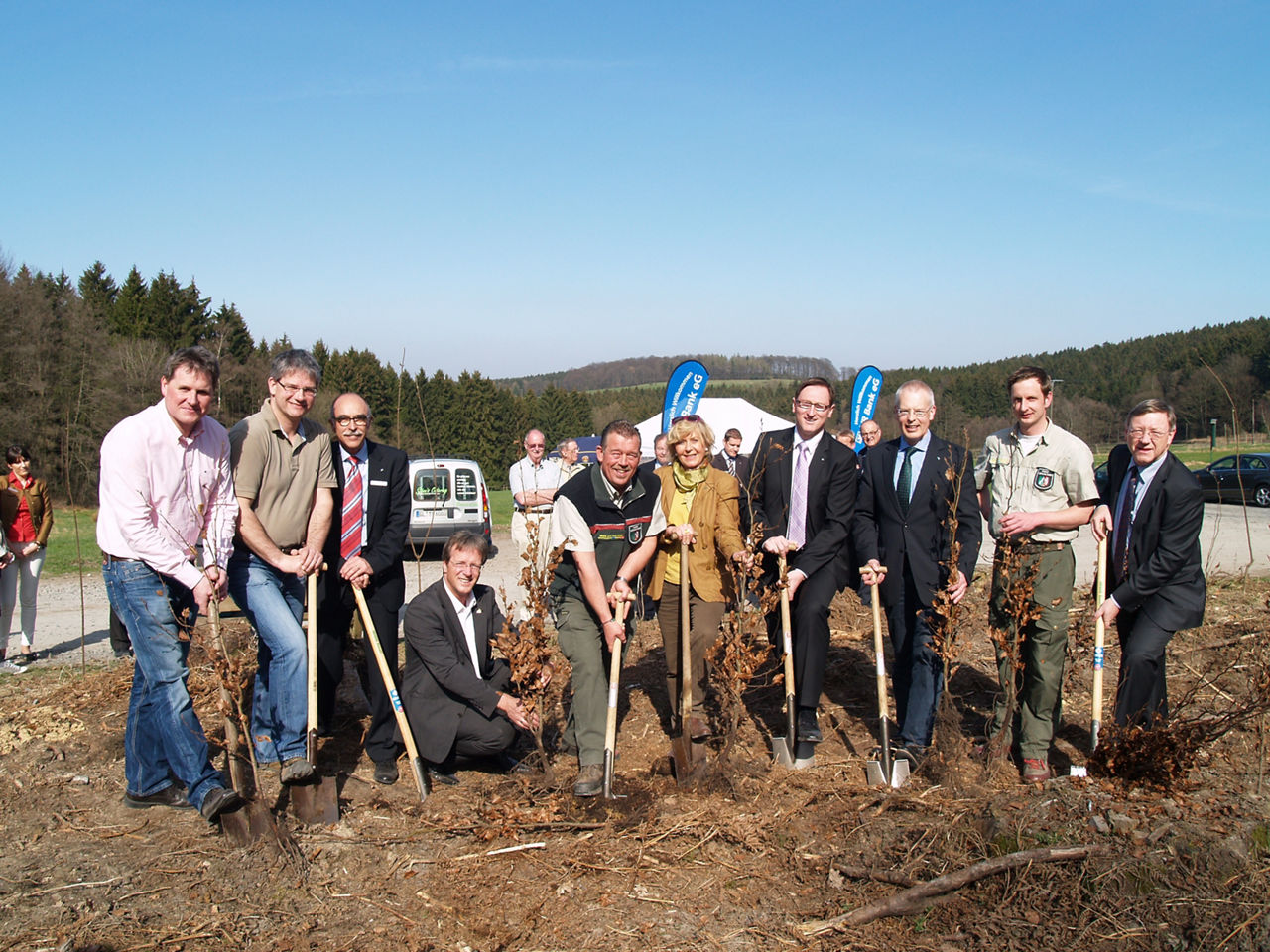 Mitgliederwald Overath - Foto: 10 Personen stehen mit einer Schaufel und Baumsetzlingen am Waldrand