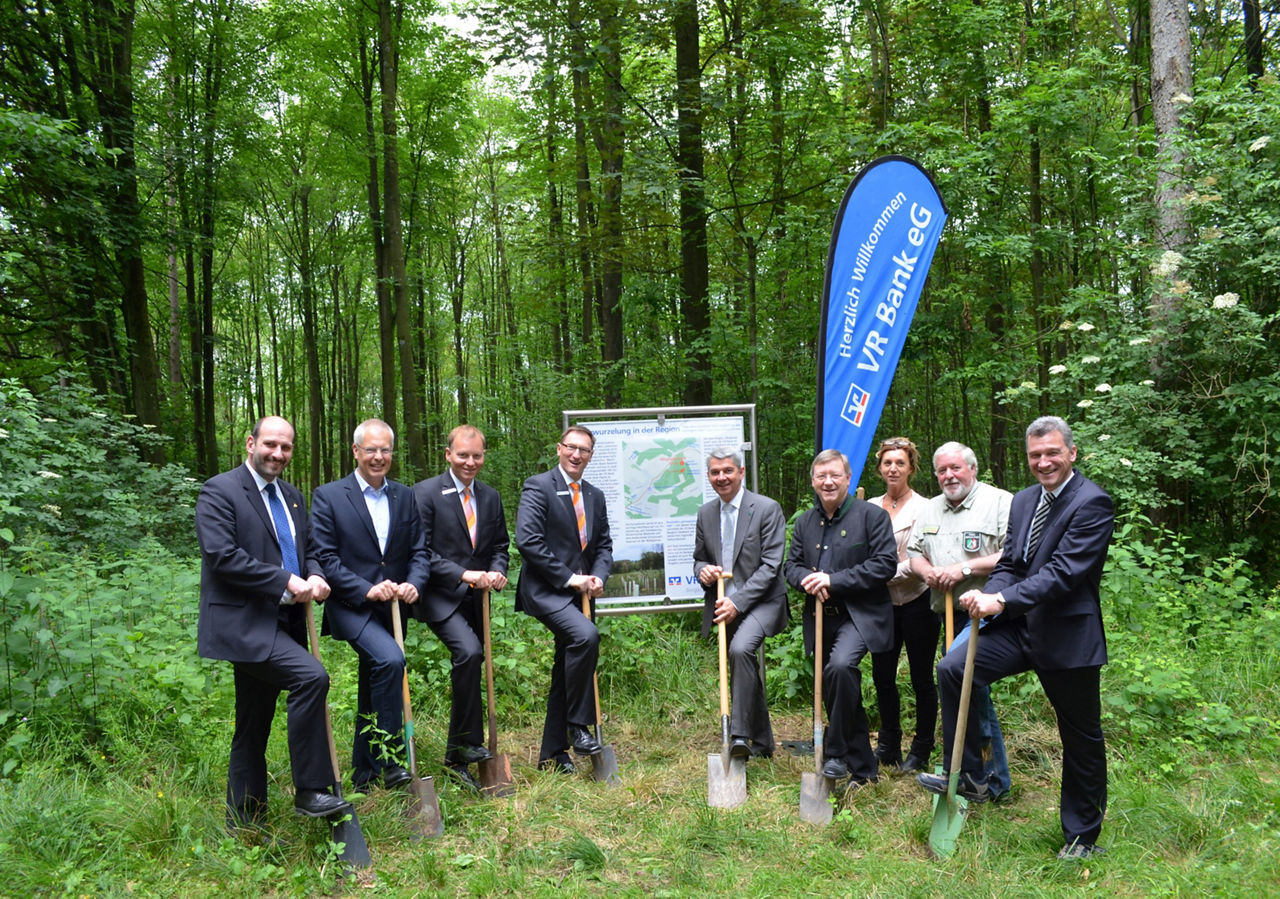 Mitgliederwald Bergisch Gladbach - Foto: 9 Personen stehen mit einer Schaufel vor einer Infotafel im Wald
