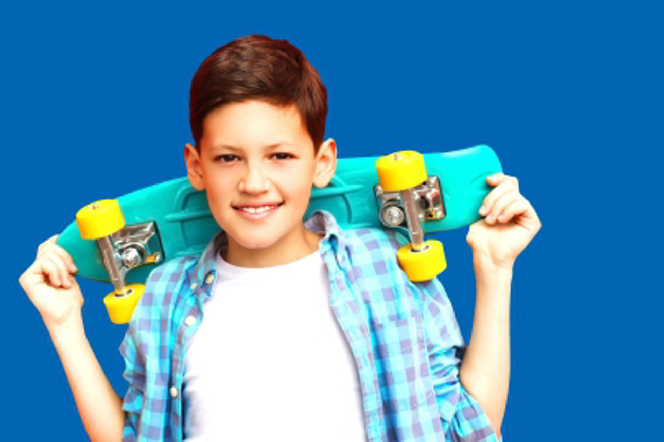 ein Junge mit einem Skateboard vor blauem Hintergrund