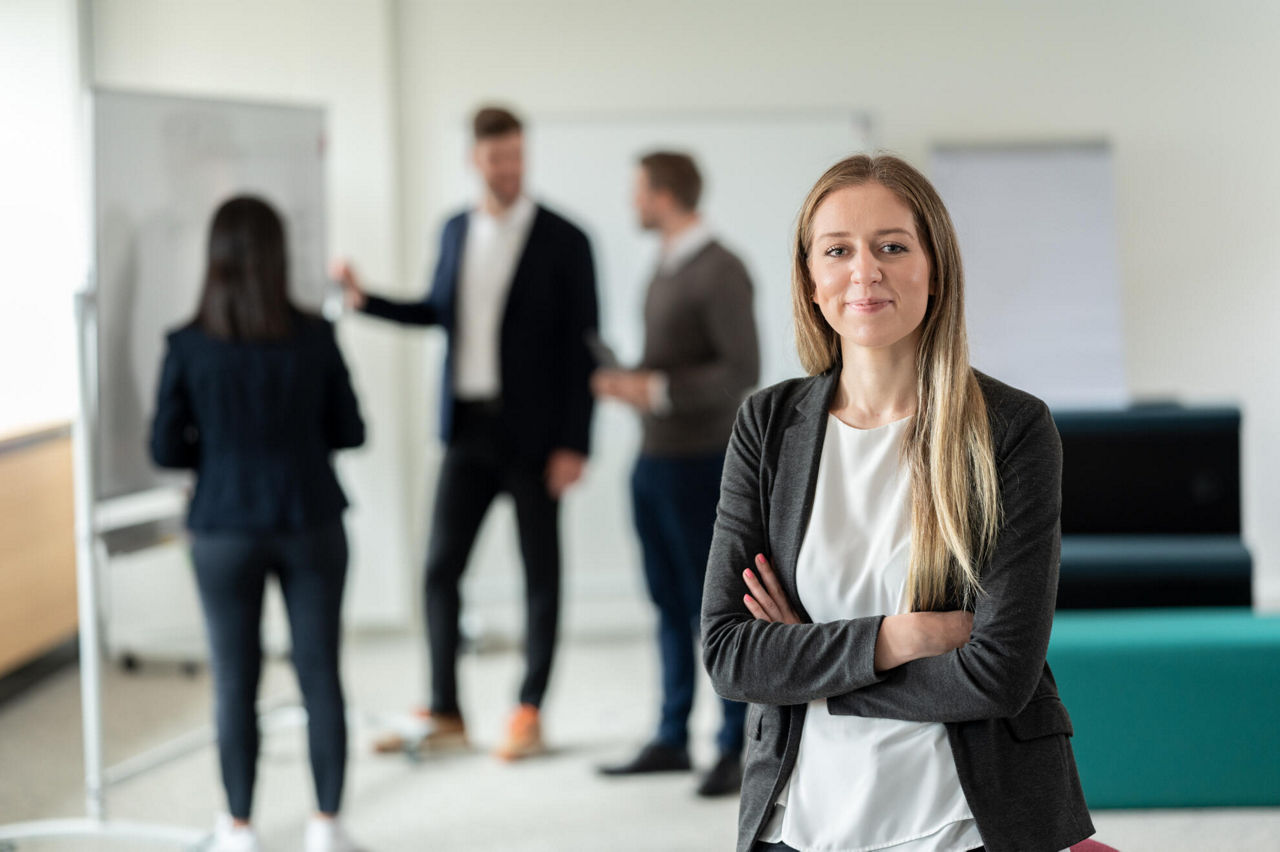 Junge Frau lächelnd stehend im Büro der Evangelischen Bank