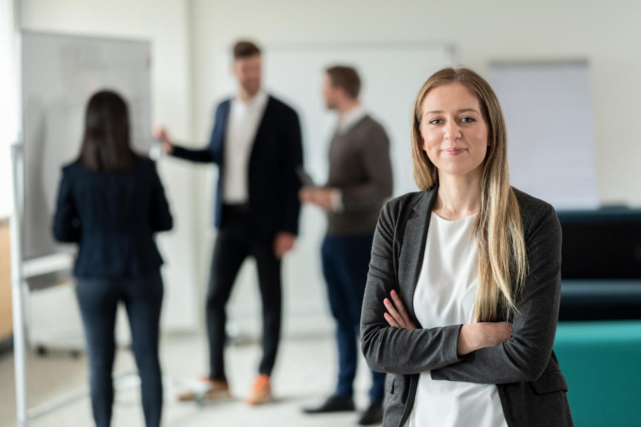 Junge Frau lächelnd stehend im Büro der Evangelischen Bank
