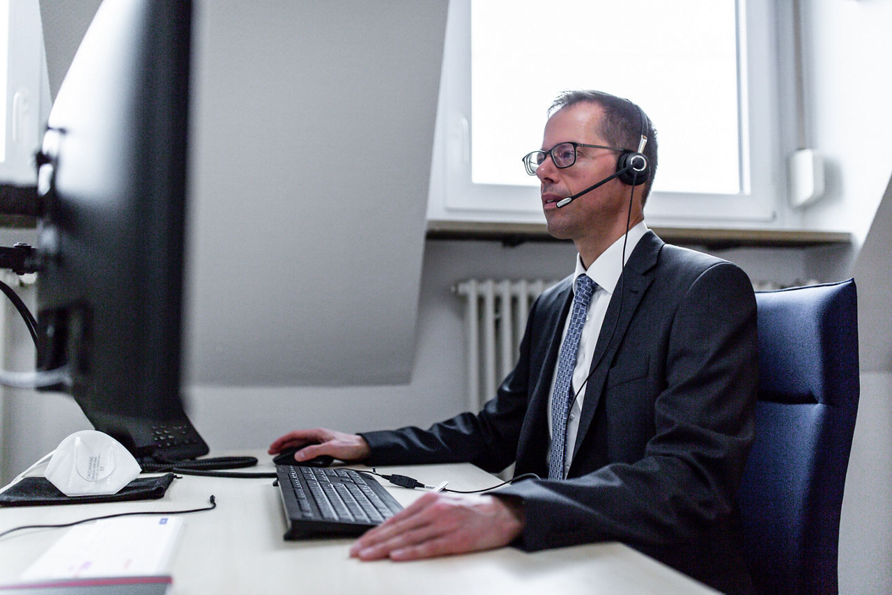 Ein Mann mit Headset am Schreibtisch