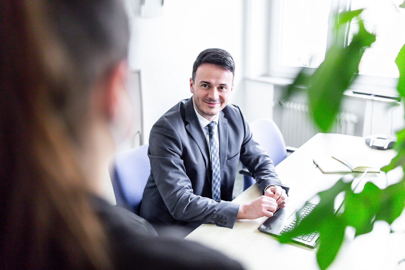 Ein jüngerer Mann unterhält sich mit einer Frau