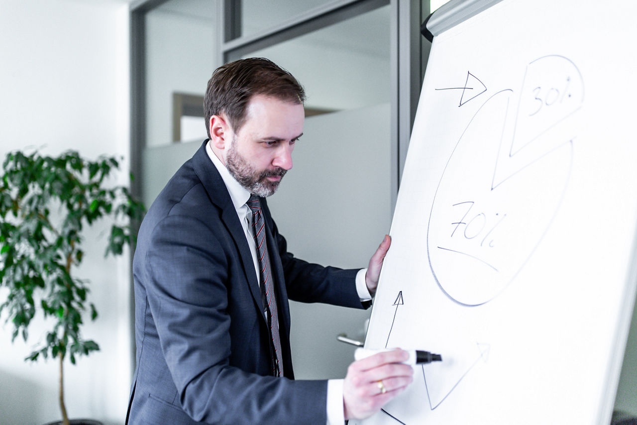 Ein Mann schreibt auf einem Flip-Chart