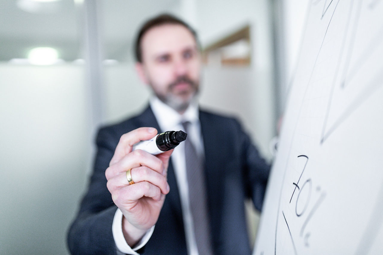 Ein Mann hebt einen Filzmarker hoch