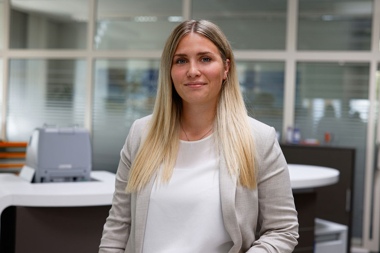 Junge Frau lächelt in einer Bankfiliale