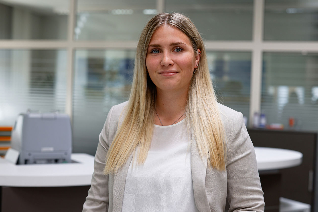 Junge Frau lächelt in einer Bankfiliale