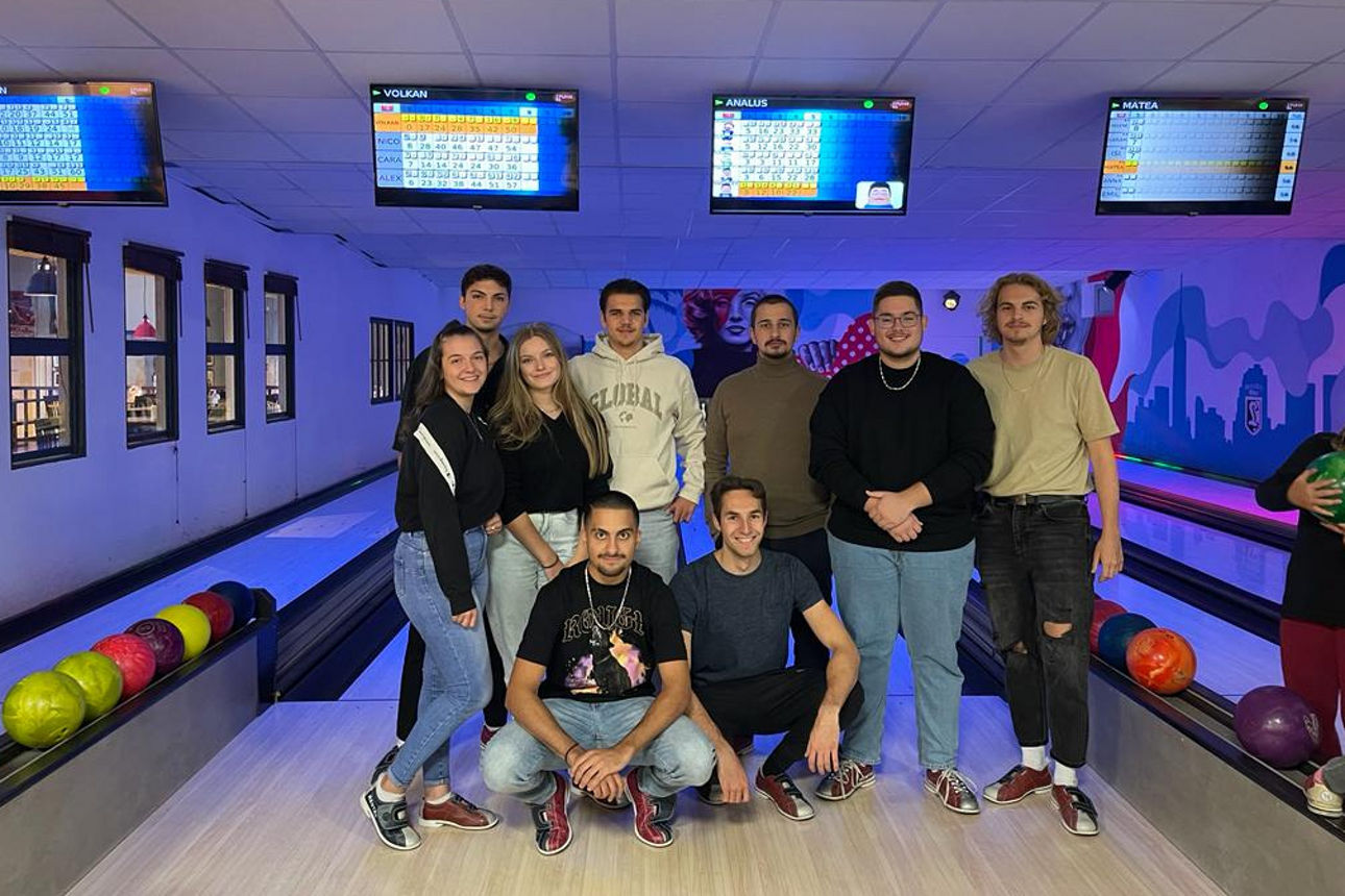 Auszubildende stehen nebeneinander in der Bowling-Halle