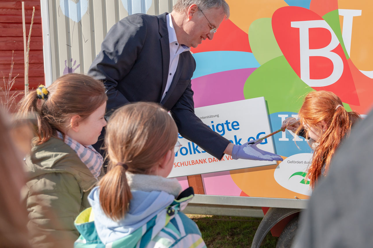 Vorstand der Bank, bei dem die Hand angemalt wird