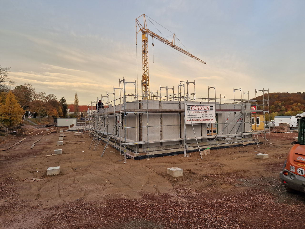Rohbau der neuen Filiale mit den ersten Wänden mit Kran im Hintergrund