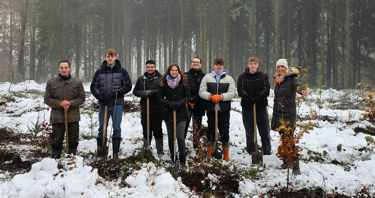 Eine Gruppe junger Leute arbeitet im Winter im Wald