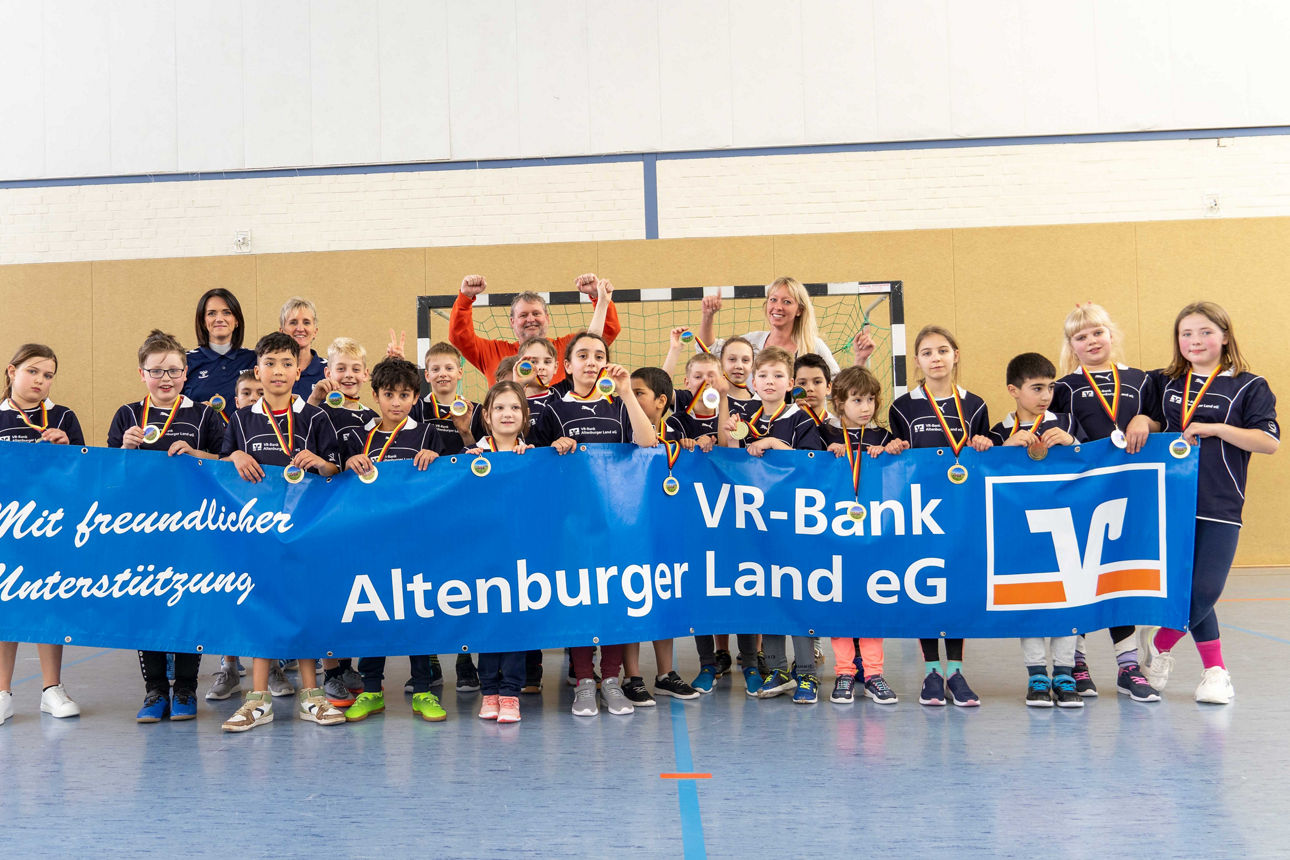 Teilnehmende Kinder halten ein Banner der VR-Bank Altenburger Land eG