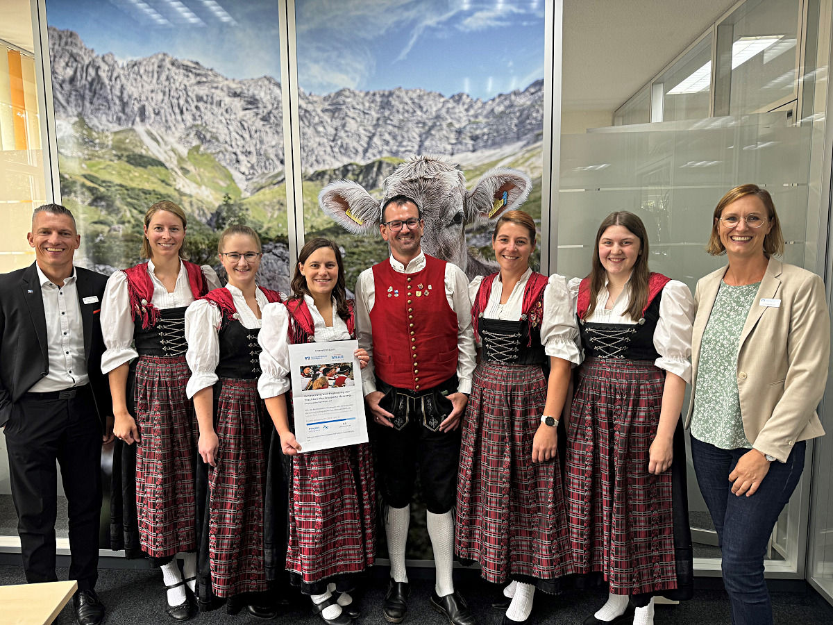 Musikkapelle steht nebeneinander mit zwei Mitarbeitern der Bank in unserer Filiale.