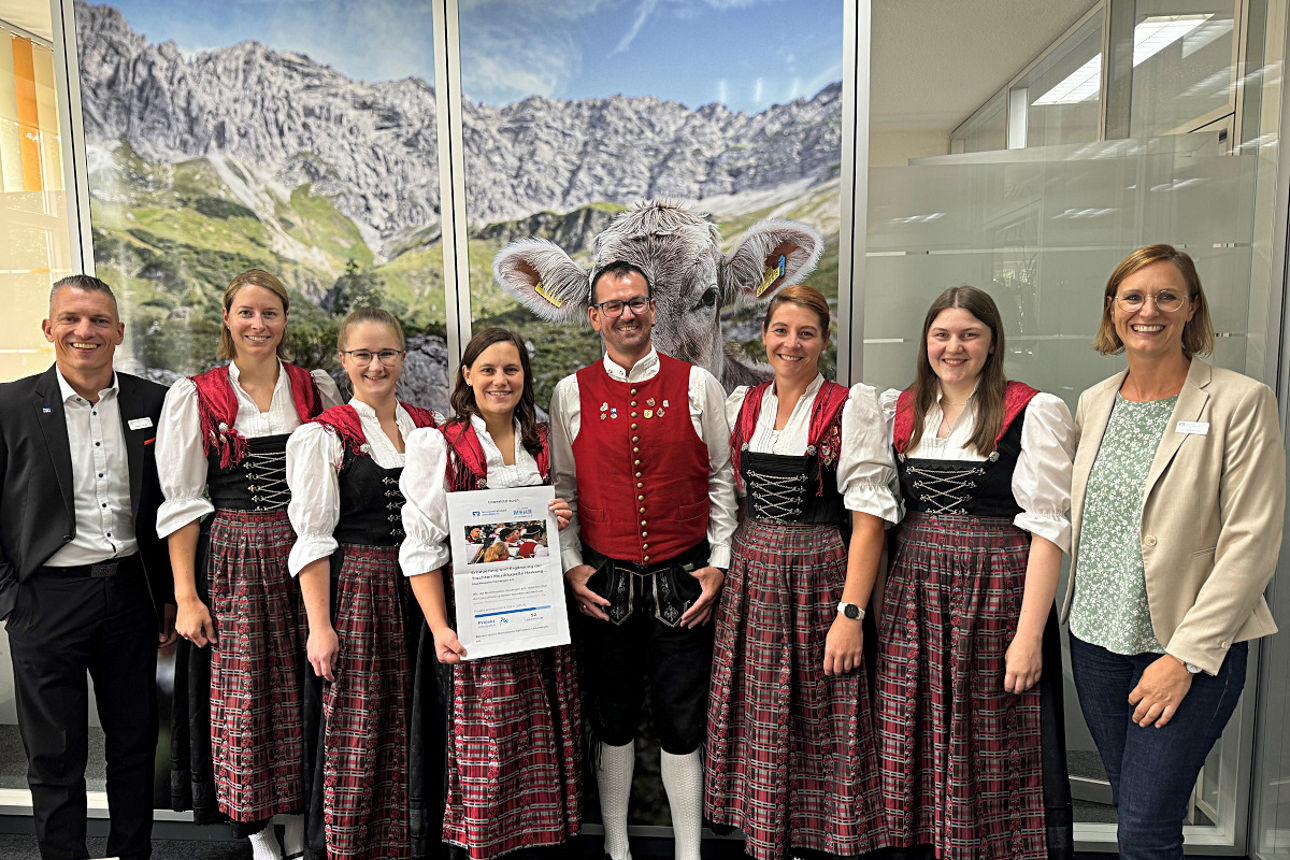 Musikkapelle steht nebeneinander mit zwei Mitarbeitern der Bank in unserer Filiale.