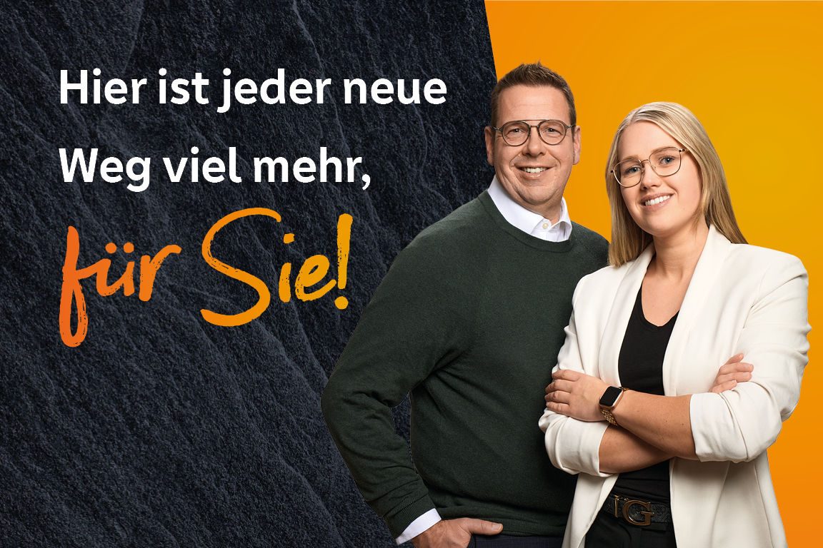 Zwei Kollegen stehen vor orangener Wand