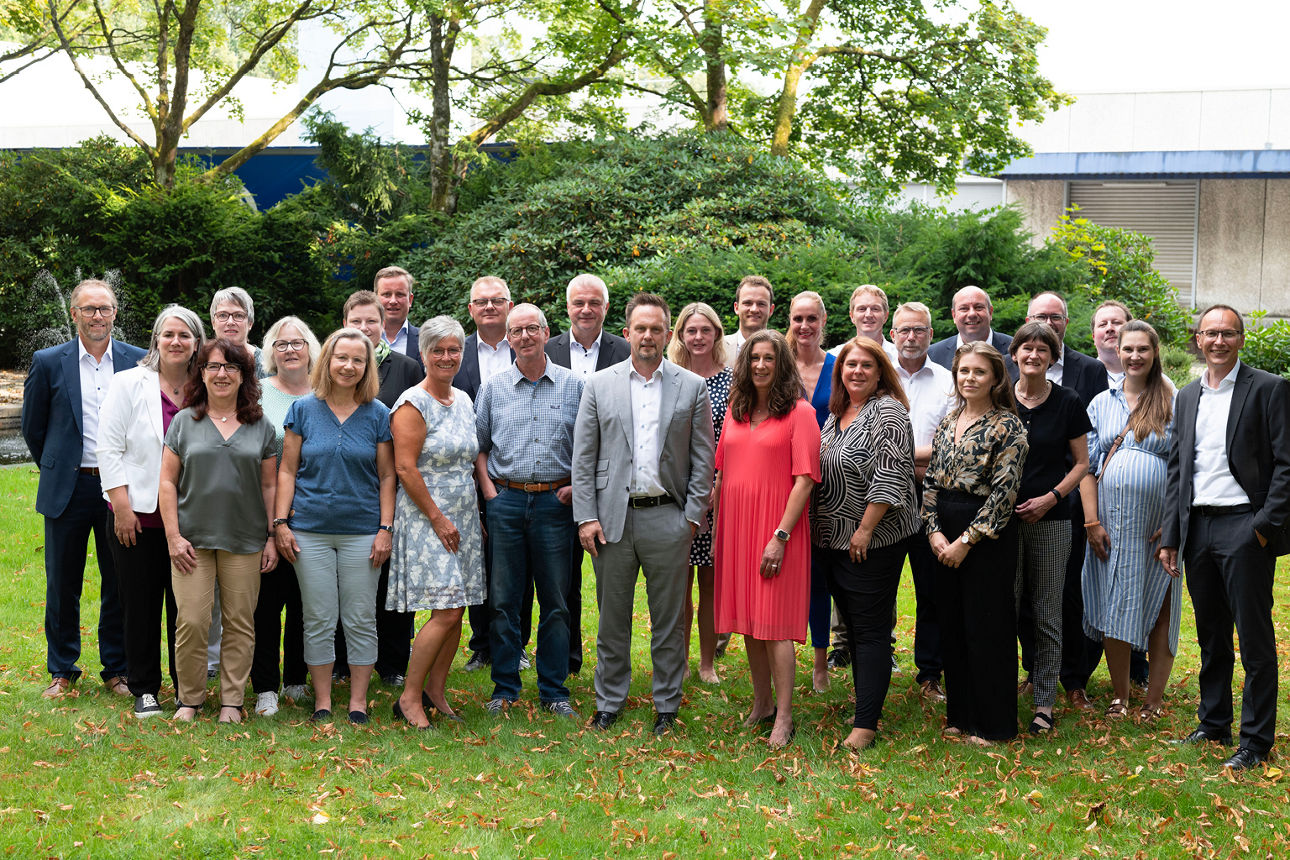 Teamfoto Jubilare vor Bäumen