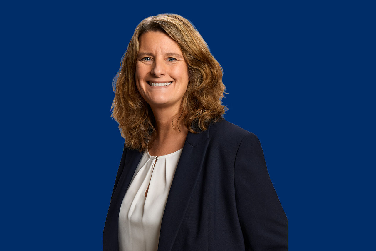 Ausbildungsverantwortliche vor blauem Hintergrund