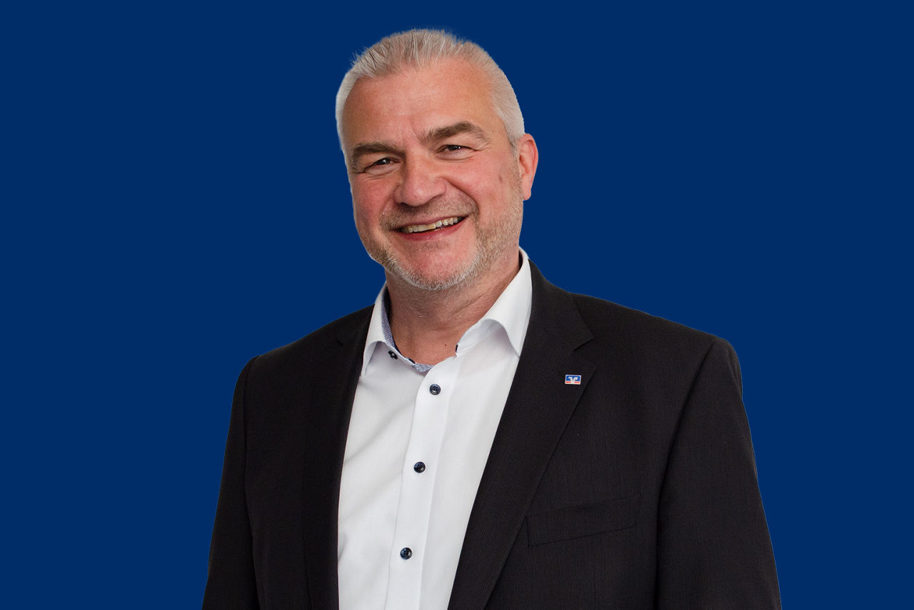 Personalleiter Thomas Willczek vor blauem Hintergrund