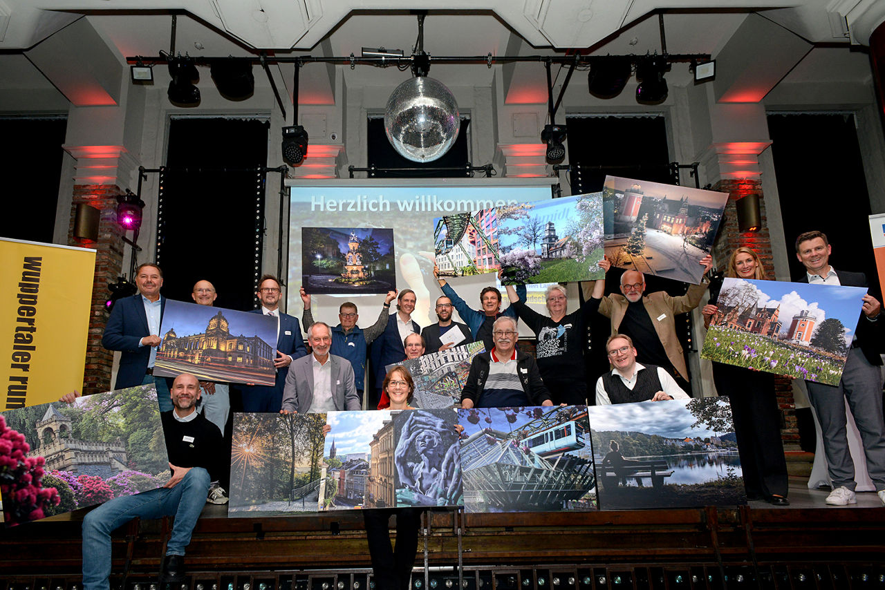 Gewinner und Jurymitglieder halten Gewinnerfotos in den Händen