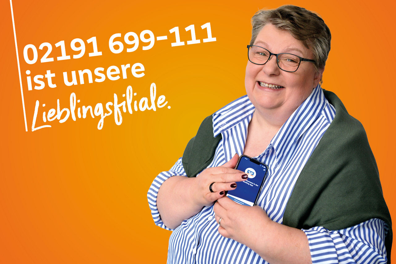 Kollegin in blauer Bluse hält Handy mit OnlineBanking-App 