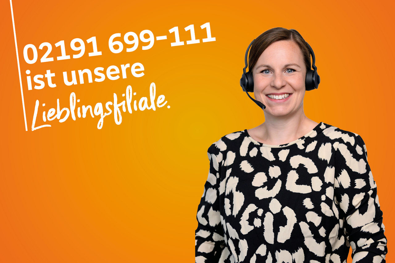 Kollegin im gemusterten Oberteil trägt Headset und strahlt