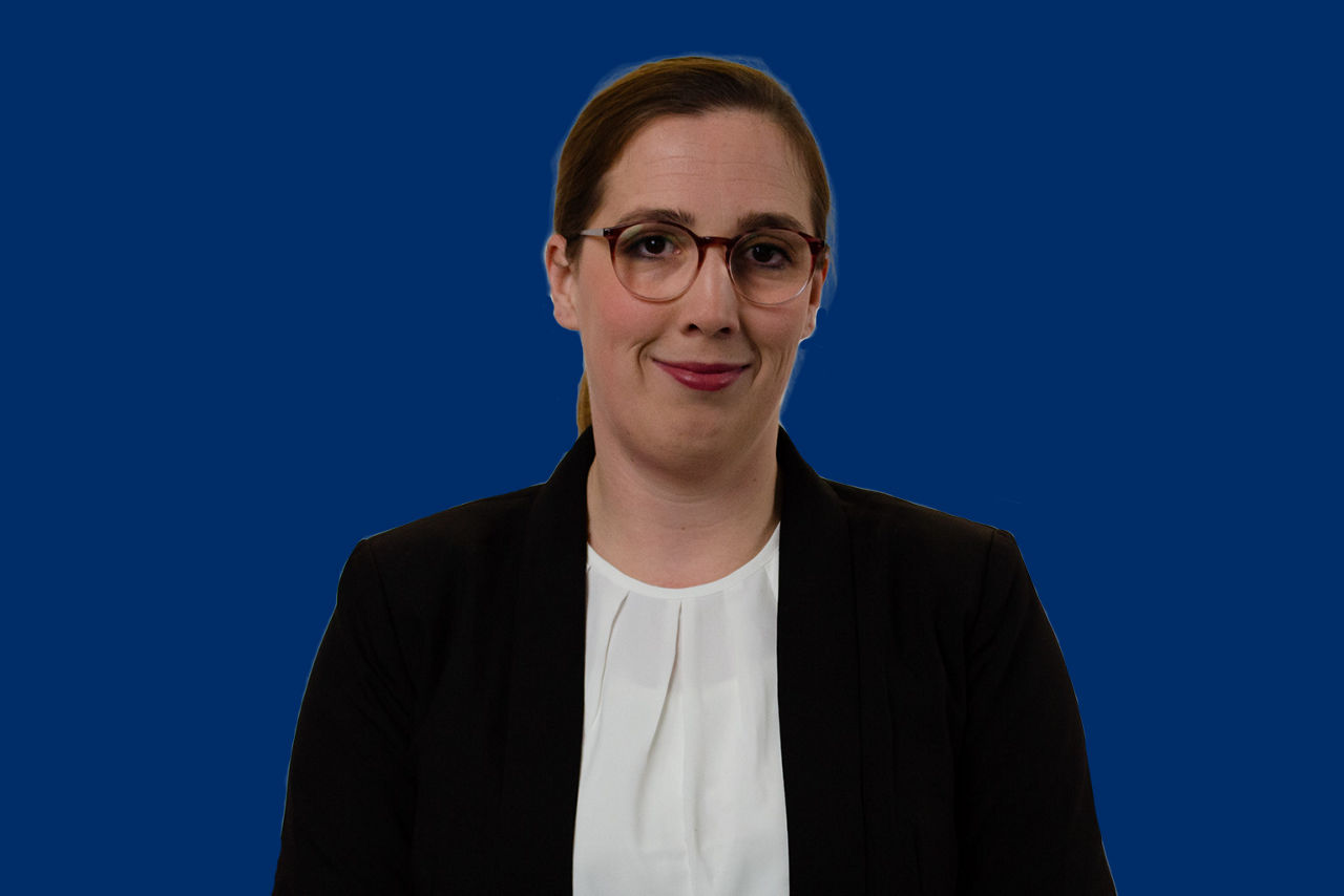 Crowdfundingexpertin Milena Ziert vor dunkelblauem Hintergrund