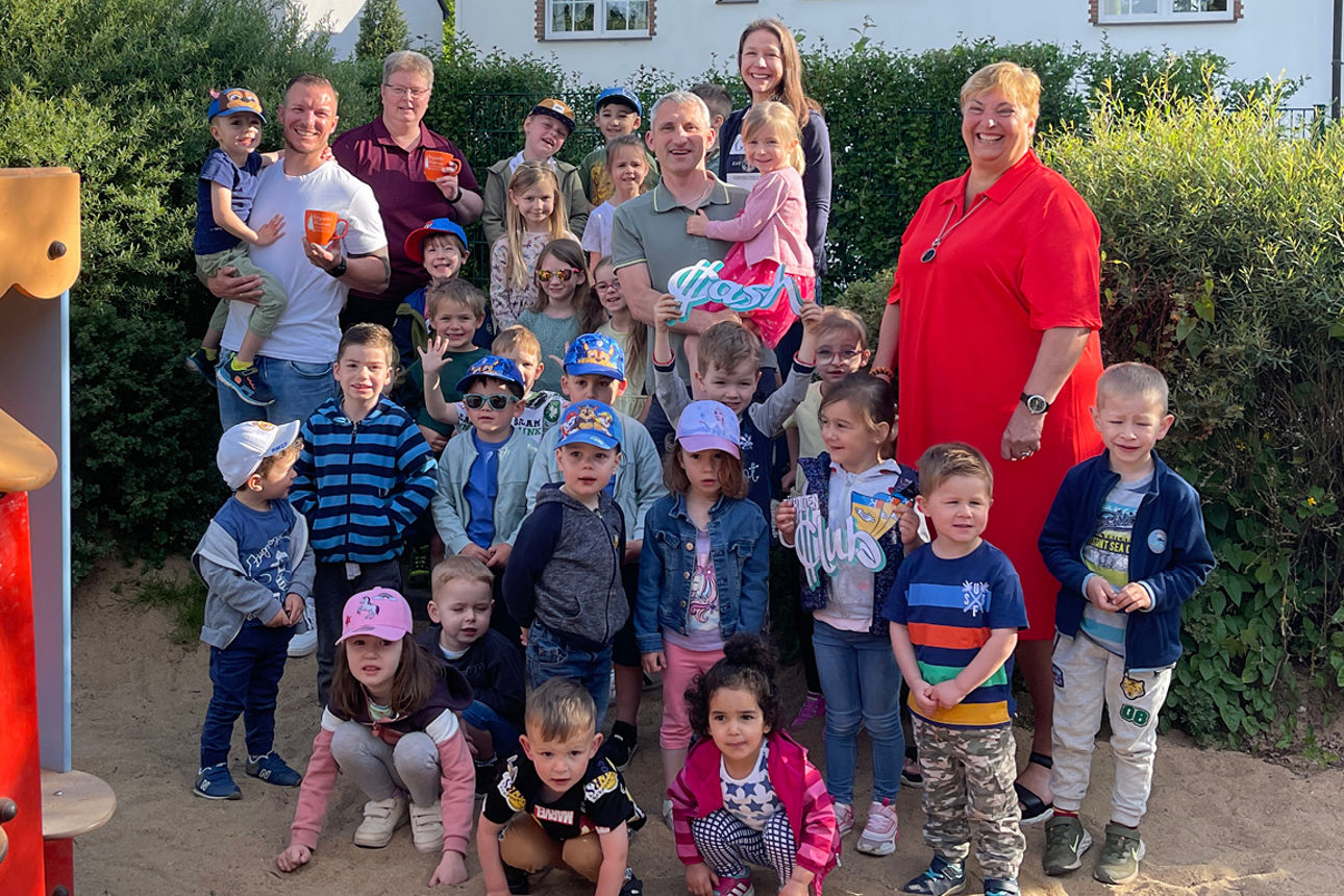 Kita Kinder stehen vor Spielgerüst und lächeln