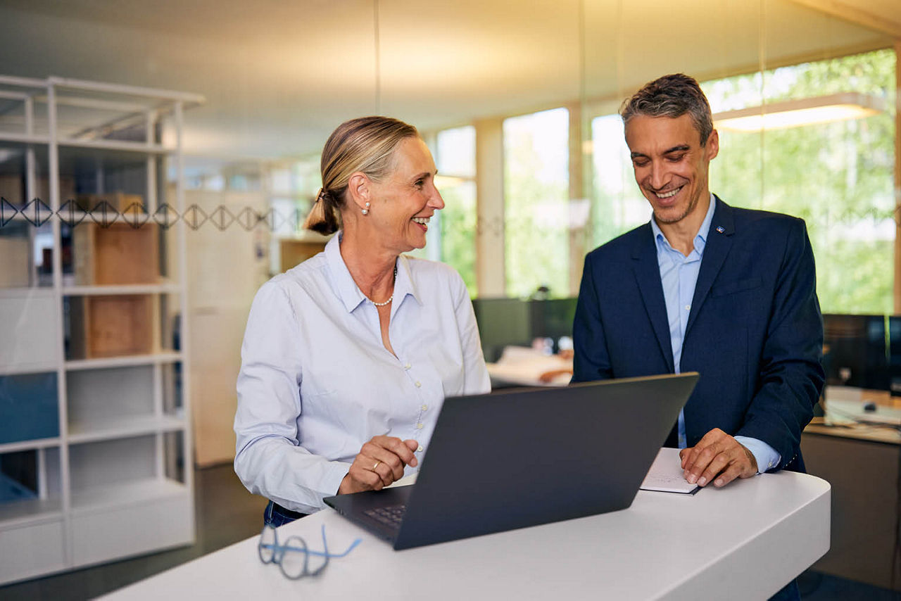 Frau am Laptop mit Mann