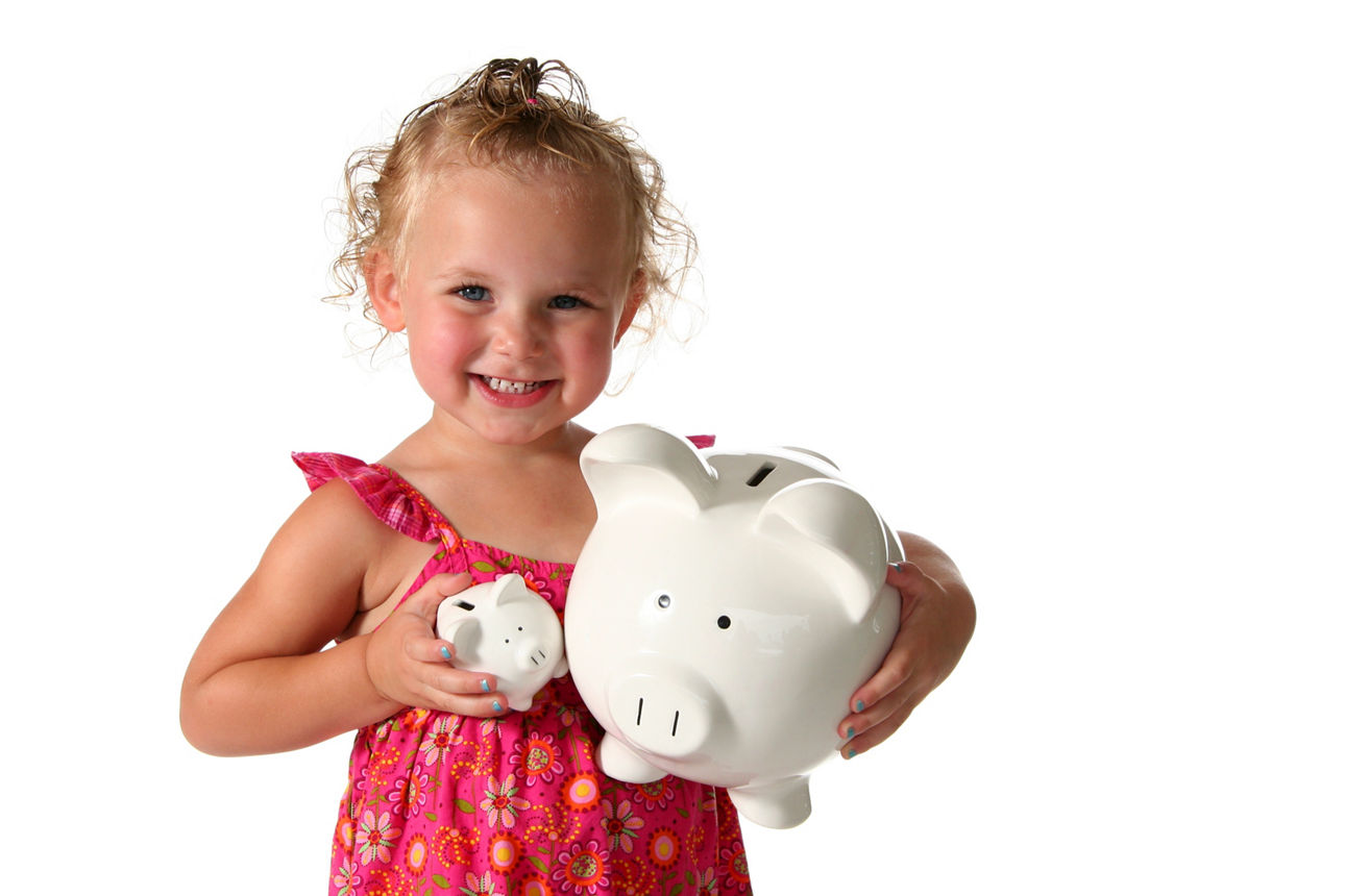 Toddler holding a large and small piggy bank on a white background