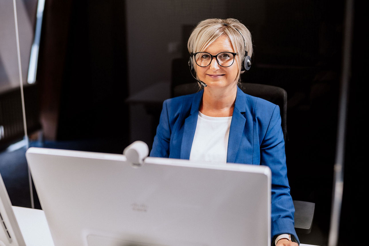 Beraterin mit Headset am Schreibtisch
