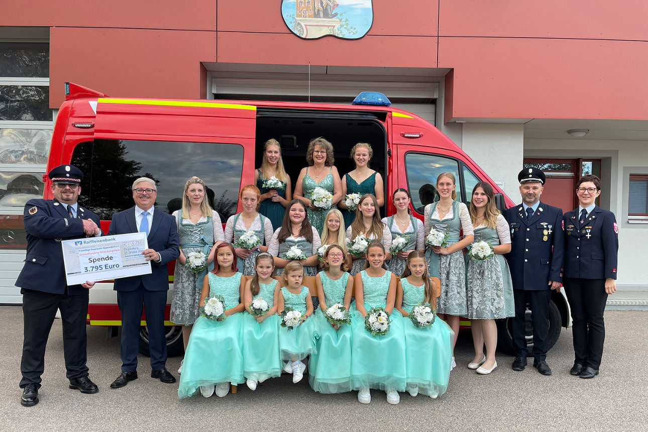 Mitglieder der Feuerwehr und der Raiffeisenbank bei der Scheckübergabe