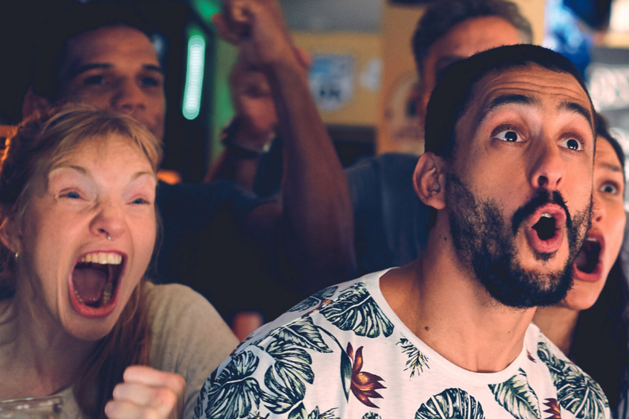 Verschiedene Menschen stehen zusammen und jubeln