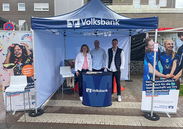 Drei Mitarbeiter unter einem Zelt beim Frühlingsfest von der Volksbank-Filiale in Münster-Hiltrup.
